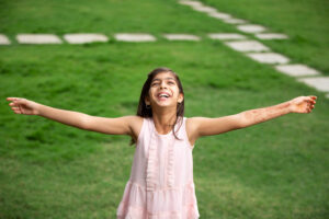 Children and teens - Happy girl smiling with open arms looking at the sky